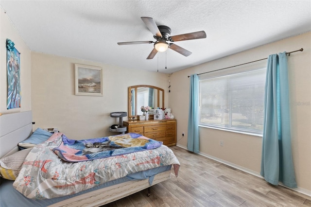 7222 Stanford Dr, Lakeland, FL 33809 - bedroom featuring wood finished floors, a ceiling fan, a textured ceiling, and baseboards