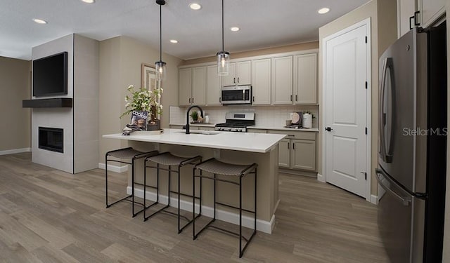9021 Players Dr, Weeki Wachee, FL 34613 - kitchen featuring appliances with stainless steel finishes, a sink, backsplash, a kitchen breakfast bar, and wood finished floors