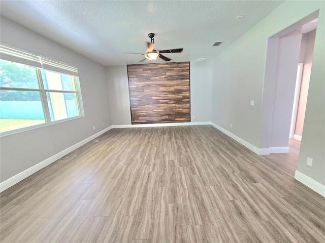 5704 Ansley Way, Mount Dora, FL 32757 - spare room with light wood-type flooring, ceiling fan, a textured ceiling, and baseboards