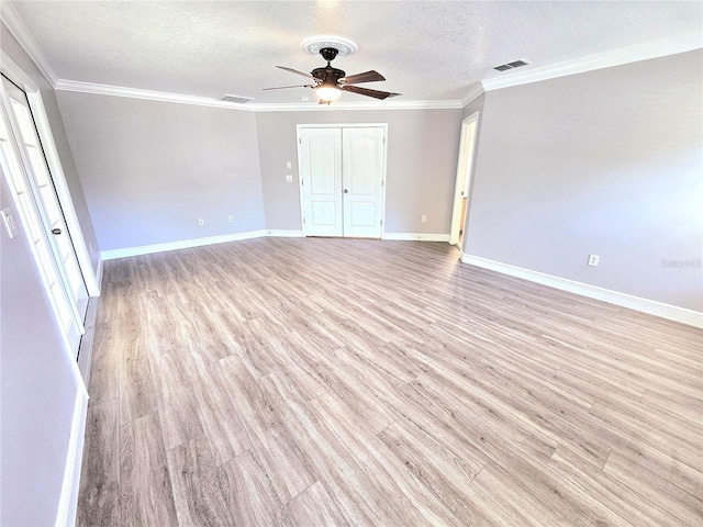5704 Ansley Way, Mount Dora, FL 32757 - unfurnished bedroom featuring light wood finished floors, a textured ceiling, a closet, baseboards, and crown molding