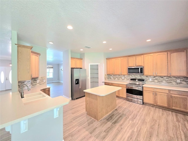 5704 Ansley Way, Mount Dora, FL 32757 - kitchen featuring appliances with stainless steel finishes, a sink, light wood-style floors, light brown cabinets, and backsplash