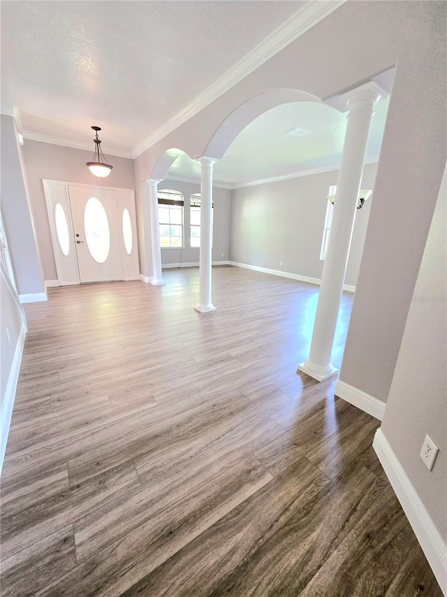 5704 Ansley Way, Mount Dora, FL 32757 - foyer featuring arched walkways, wood finished floors, baseboards, crown molding, and decorative columns