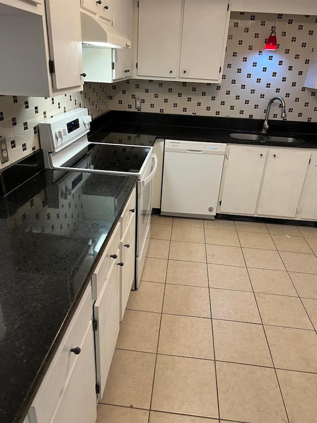 kitchen with under cabinet range hood, white appliances, a sink, and backsplash
