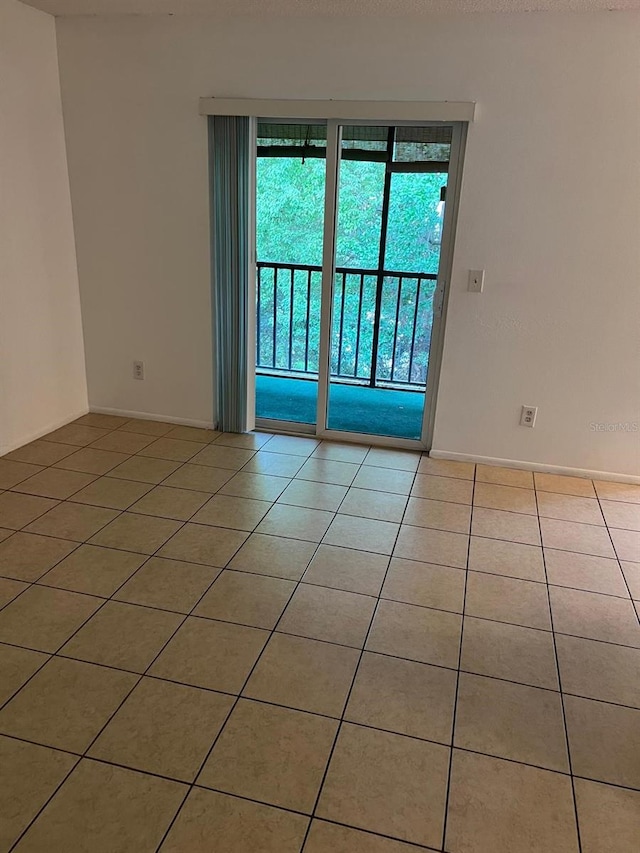 tiled spare room featuring baseboards
