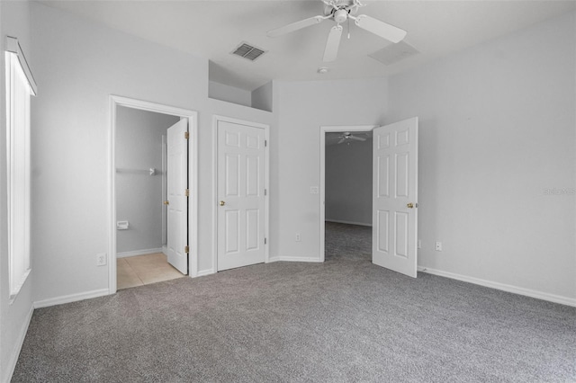 16614 Lazy Breeze Loop, Clermont, FL 34714 - unfurnished bedroom featuring carpet floors, a walk in closet, baseboards, ensuite bathroom, and a ceiling fan