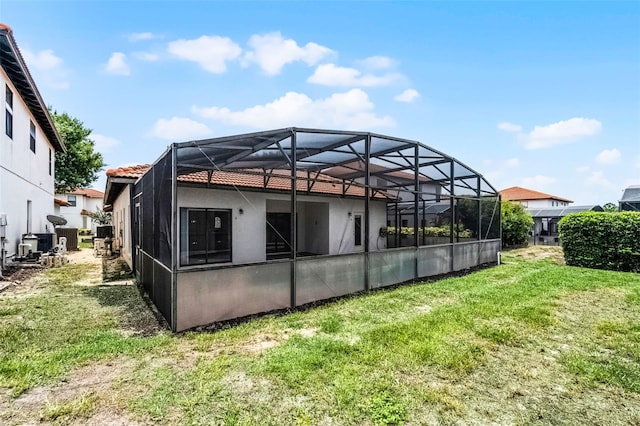 16614 Lazy Breeze Loop, Clermont, FL 34714 - rear view of property with a lawn, stucco siding, a tiled roof, and glass enclosure