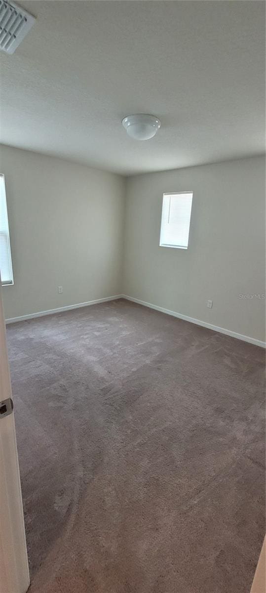 1556 Aspen Ave, Davenport, FL 33837 - unfurnished room featuring dark carpet and baseboards
