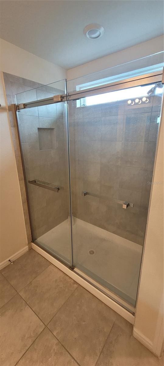 1556 Aspen Ave, Davenport, FL 33837 - full bathroom with tile patterned flooring, a stall shower, and baseboards