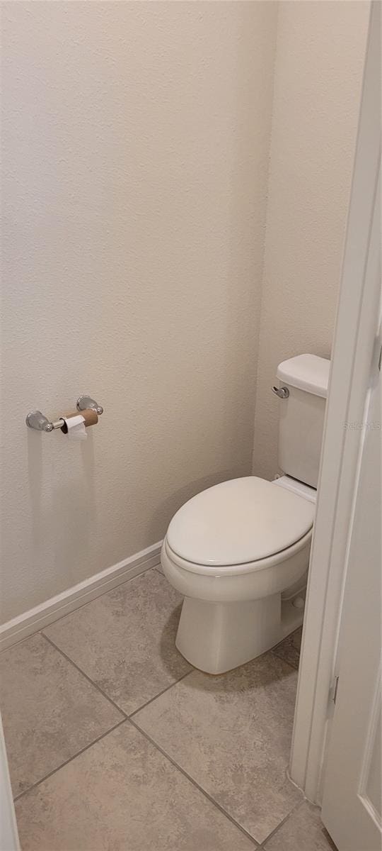 1556 Aspen Ave, Davenport, FL 33837 - bathroom featuring tile patterned floors, toilet, and baseboards