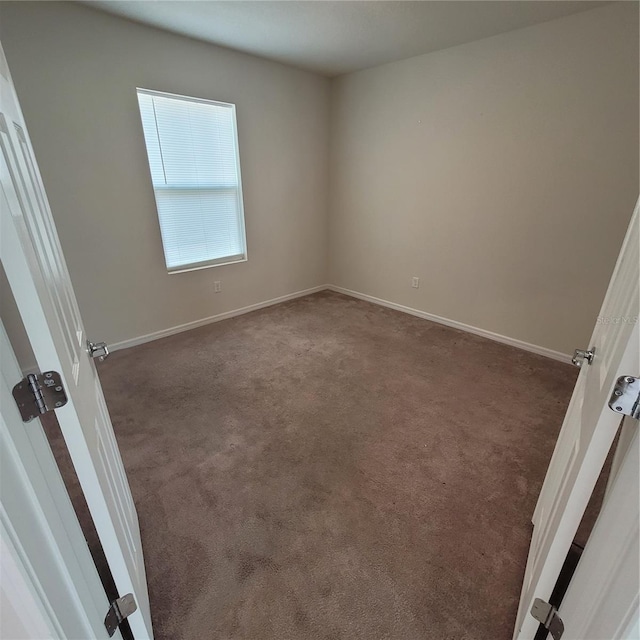 1556 Aspen Ave, Davenport, FL 33837 - unfurnished room with dark colored carpet and baseboards