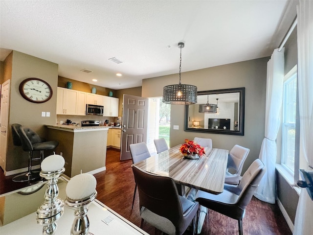5356 Diplomat Ct Unit 108, Kissimmee, FL 34746 - dining area featuring dark wood-type flooring, baseboards, and a textured ceiling