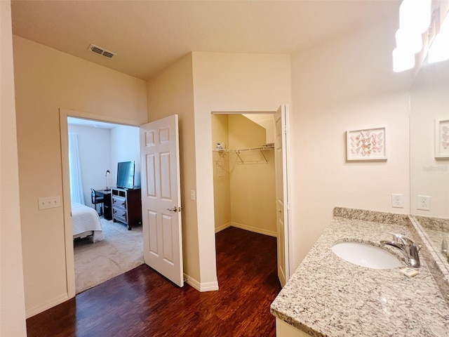 5356 Diplomat Ct Unit 108, Kissimmee, FL 34746 - full bathroom with wood finished floors, vanity, a spacious closet, and baseboards