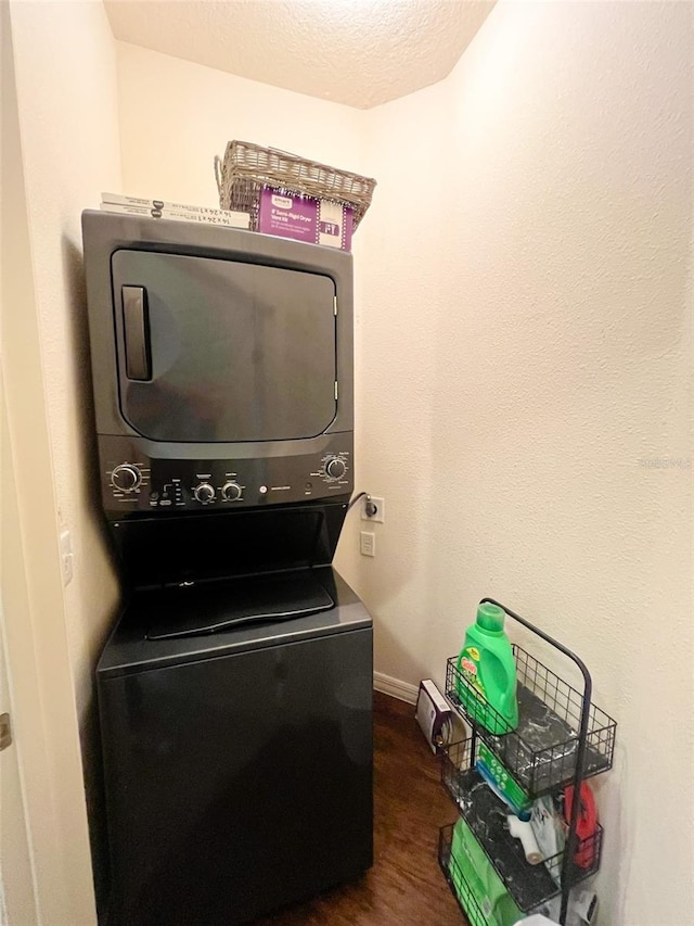5356 Diplomat Ct Unit 108, Kissimmee, FL 34746 - laundry area featuring stacked washer / drying machine, dark wood finished floors, baseboards, and a textured ceiling
