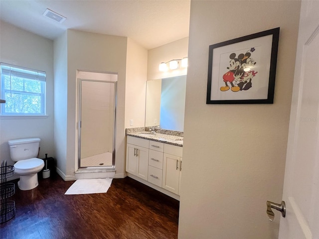 5356 Diplomat Ct Unit 108, Kissimmee, FL 34746 - bathroom featuring toilet, double vanity, a stall shower, wood finished floors, and baseboards