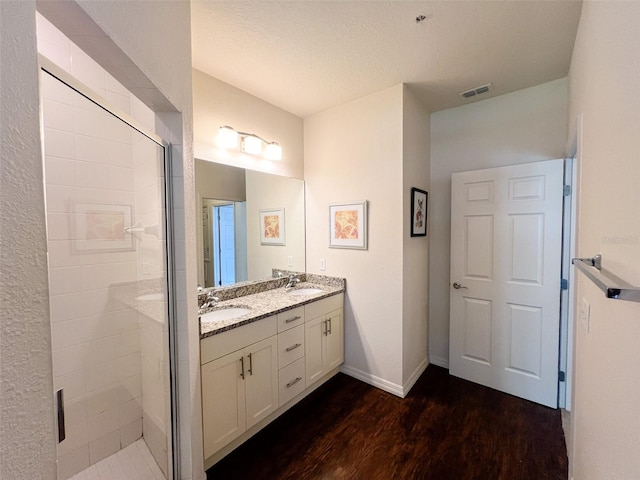 5356 Diplomat Ct Unit 108, Kissimmee, FL 34746 - bathroom with double vanity, wood finished floors, a stall shower, and baseboards