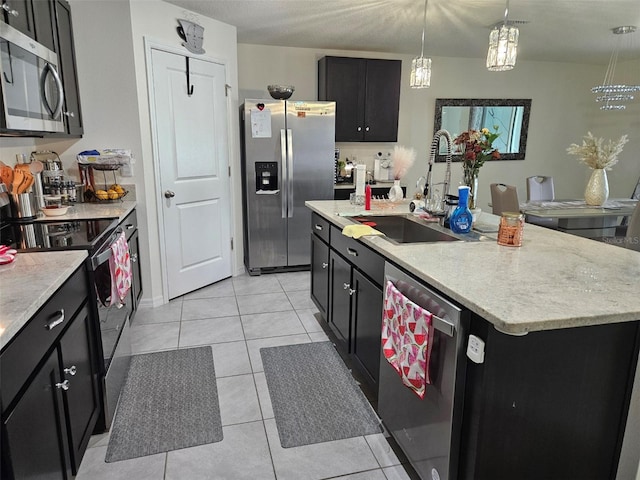 6315 Hillview Rd, Spring Hill, FL 34606 - kitchen with appliances with stainless steel finishes, a sink, dark cabinetry, and a kitchen island with sink