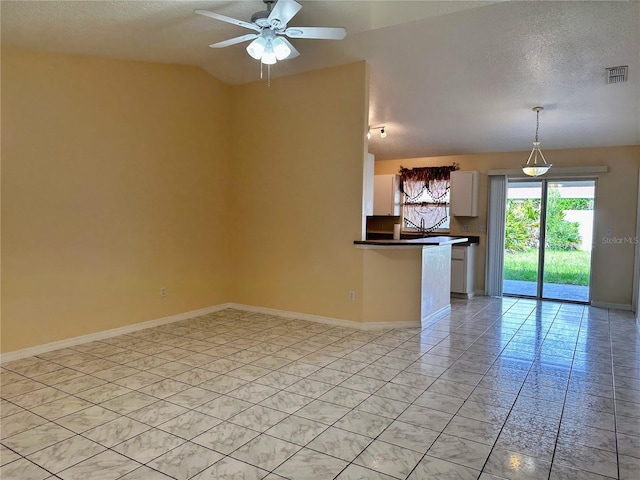 19 Rainbow Ln, Palm Coast, FL 32164 - unfurnished living room featuring a textured ceiling, a ceiling fan, and baseboards
