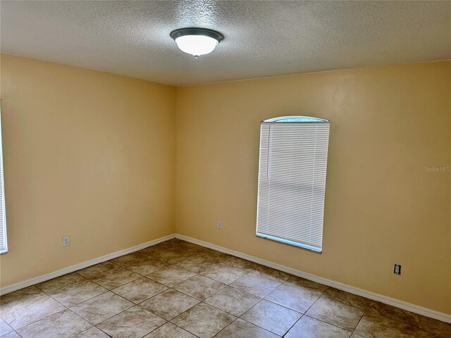19 Rainbow Ln, Palm Coast, FL 32164 - spare room featuring a textured ceiling and light tile patterned floors
