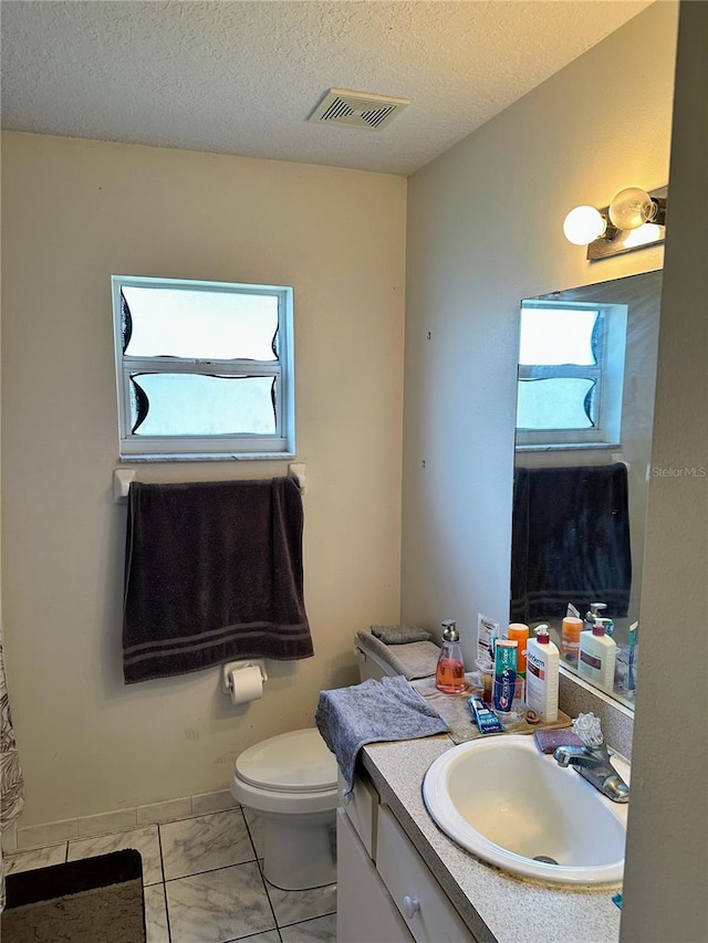 19 Rainbow Ln, Palm Coast, FL 32164 - bathroom with marble finish floors, vanity, toilet, and a textured ceiling