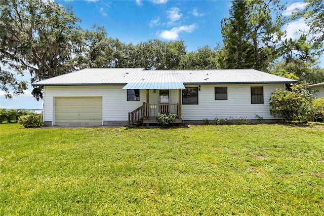 2740 Barker Rd, Saint Cloud, FL 34771 - view of front of house featuring a garage, a metal roof, a front lawn, and asphalt driveway