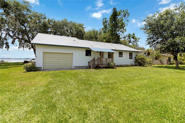 2740 Barker Rd, Saint Cloud, FL 34771 - back of house with a garage, a yard, a metal roof, and driveway