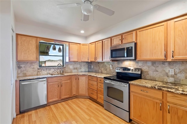 2740 Barker Rd, Saint Cloud, FL 34771 - kitchen featuring stainless steel appliances, light wood-style floors, light stone counters, and decorative backsplash
