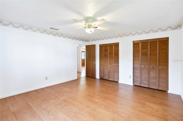 2740 Barker Rd, Saint Cloud, FL 34771 - unfurnished bedroom featuring two closets, light wood finished floors, and a ceiling fan