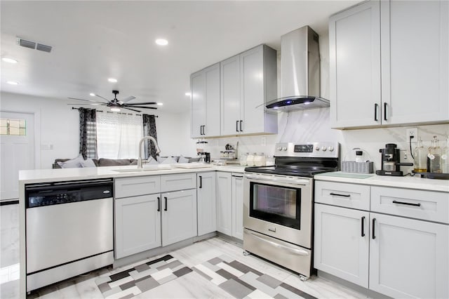 416 E Seminole Ave, Lake Wales, FL 33853 - kitchen with appliances with stainless steel finishes, wall chimney range hood, a peninsula, a sink, and open floor plan