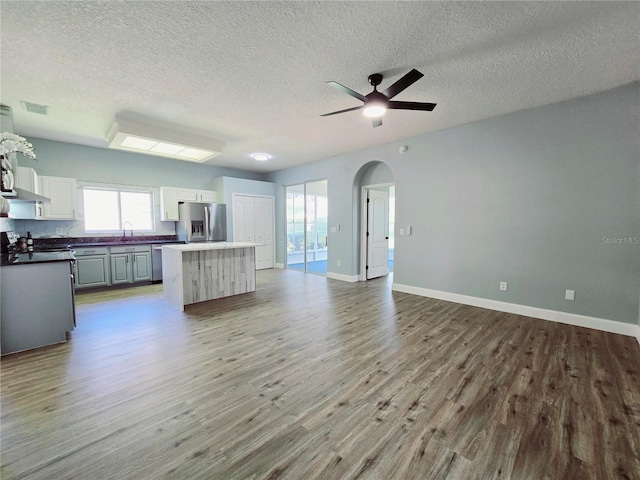 2312 Twickingham Ct, Clermont, FL 34711 - kitchen featuring stainless steel appliances, a sink, open floor plan, wood finished floors, and a center island