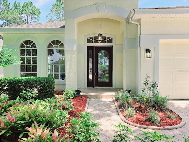 2312 Twickingham Ct, Clermont, FL 34711 - doorway to property featuring an attached garage, stucco siding, and roof with shingles
