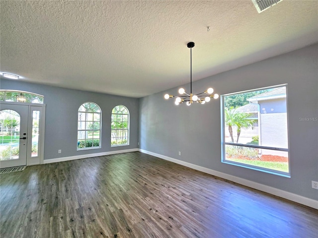2312 Twickingham Ct, Clermont, FL 34711 - spare room with a chandelier, plenty of natural light, dark wood-style floors, and a textured ceiling