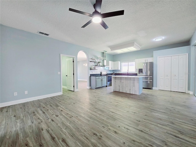 2312 Twickingham Ct, Clermont, FL 34711 - kitchen featuring appliances with stainless steel finishes, a textured ceiling, a ceiling fan, open floor plan, and light wood-style floors