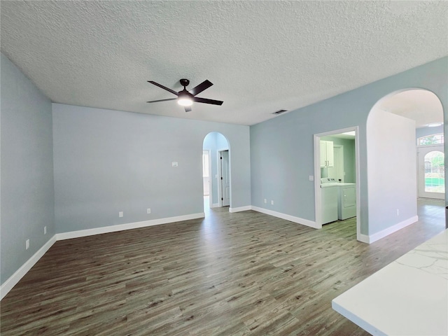 2312 Twickingham Ct, Clermont, FL 34711 - unfurnished room with arched walkways, wood finished floors, a ceiling fan, washer / dryer, and a textured ceiling