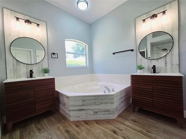 2312 Twickingham Ct, Clermont, FL 34711 - bathroom with wood finished floors, a garden tub, and two vanities