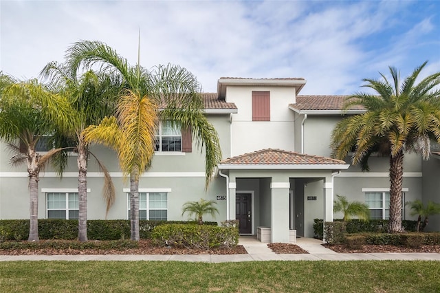 4875 Clock Tower Dr, Kissimmee, FL 34746 - view of front of home featuring stucco siding, a tile roof, and a front yard