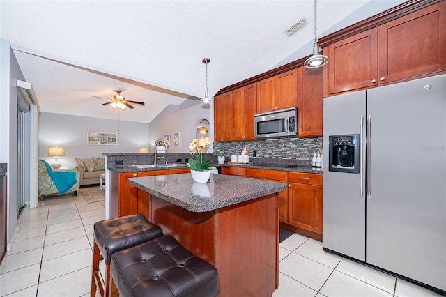 812 Adour Dr, Kissimmee, FL 34759 - kitchen featuring appliances with stainless steel finishes, light tile patterned floors, lofted ceiling, open floor plan, and decorative backsplash