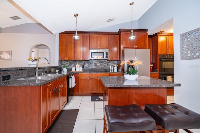 812 Adour Dr, Kissimmee, FL 34759 - kitchen with black appliances, vaulted ceiling, tasteful backsplash, light tile patterned floors, and a peninsula