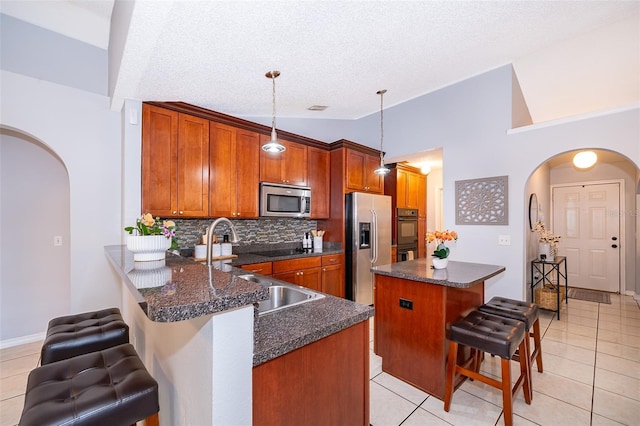 812 Adour Dr, Kissimmee, FL 34759 - kitchen featuring black appliances, arched walkways, a breakfast bar area, tasteful backsplash, and vaulted ceiling