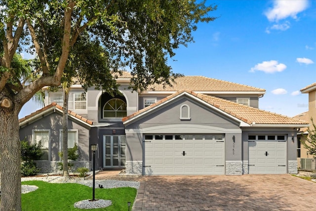 3759 Eagle Isle Cir, Kissimmee, FL 34746 - view of front of house featuring stone siding, decorative driveway, stucco siding, and cooling unit