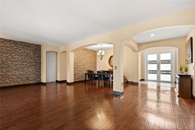 3759 Eagle Isle Cir, Kissimmee, FL 34746 - unfurnished living room with arched walkways, a chandelier, and wood-type flooring