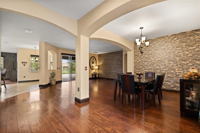 3759 Eagle Isle Cir, Kissimmee, FL 34746 - dining space featuring a chandelier, wood finished floors, arched walkways, and baseboards