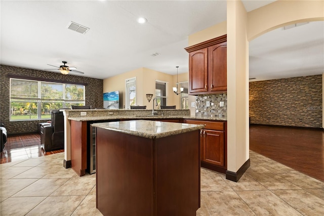 3759 Eagle Isle Cir, Kissimmee, FL 34746 - kitchen with a peninsula, light tile patterned floors, a ceiling fan, light stone counters, and recessed lighting