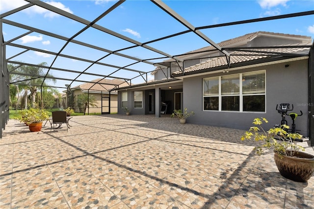 3759 Eagle Isle Cir, Kissimmee, FL 34746 - rear view of property with a patio, stucco siding, and glass enclosure