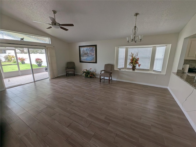 5921 Lake Champlain Dr, Orlando, FL 32829 - unfurnished room featuring a chandelier, a textured ceiling, a ceiling fan, dark wood-style flooring, and healthy amount of natural light