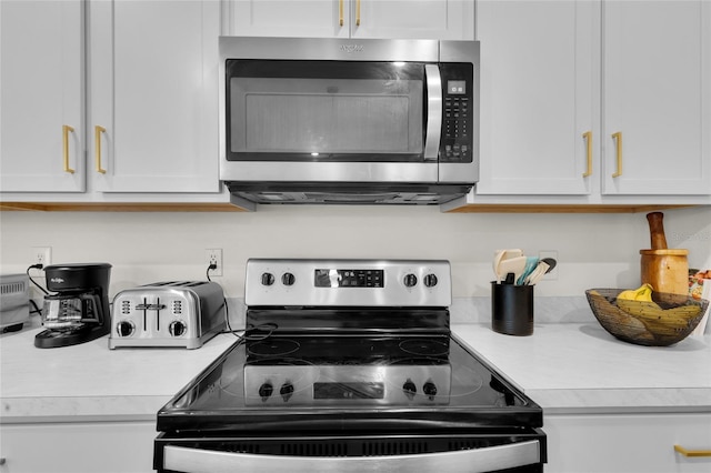 685 Overpool Ave, Davenport, FL 33896 - kitchen with stainless steel appliances, light countertops, and white cabinets