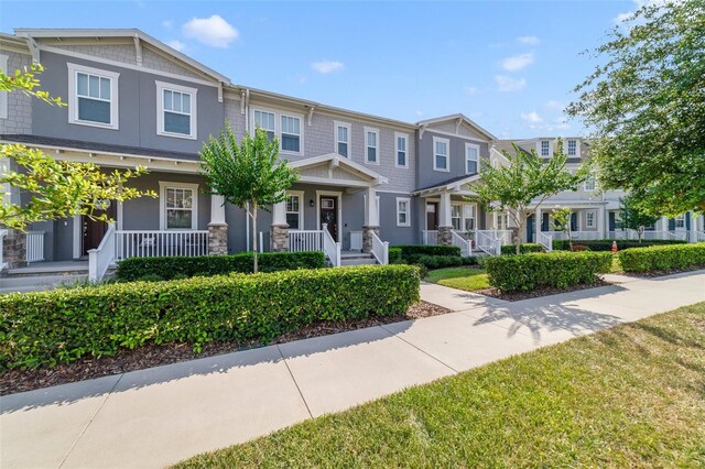 2224 Celebration Blvd, Celebration, FL 34747 - townhome / multi-family property featuring covered porch, a residential view, and stucco siding