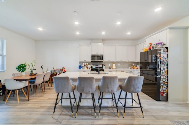 2224 Celebration Blvd, Celebration, FL 34747 - kitchen with stainless steel microwave, a sink, freestanding refrigerator, light wood-style floors, and recessed lighting
