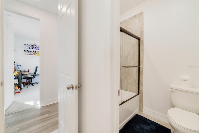 2224 Celebration Blvd, Celebration, FL 34747 - full bathroom featuring toilet, bath / shower combo with glass door, baseboards, and wood finished floors