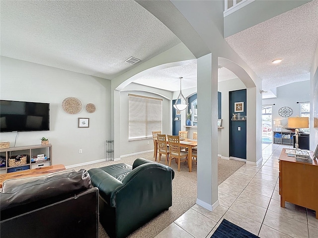 1426 Park Park, Haines City, FL 33844 - living room featuring a textured ceiling, arched walkways, light tile patterned flooring, and light colored carpet