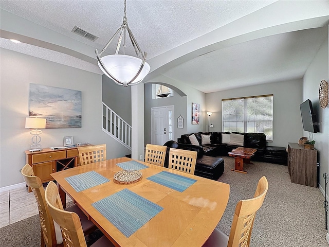1426 Park Park, Haines City, FL 33844 - tiled dining area featuring arched walkways, stairs, carpet floors, and a textured ceiling
